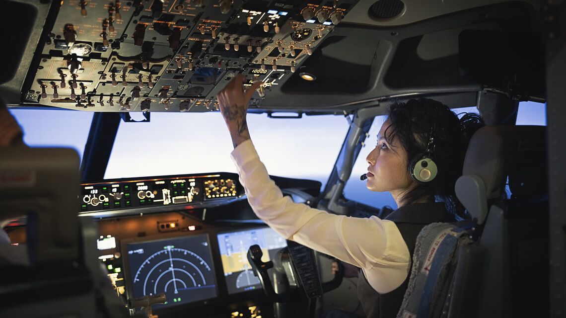 A first officer at the cockpit controls